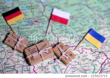 The flags of Germany, Poland and Ukraine lie on a world map next to delivered parcels. Economy, aid, trade 125023713