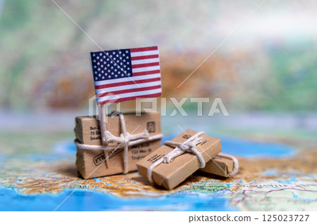 Flag of USA near the parcels on the world map. World trade. Exports and imports of goods. Economy of the country. Flag of USA near the parcels on the world map. World trade. Exports and imports of goods. Economy of the country. 125023727