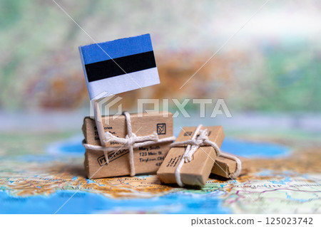 Flag of Estonia near the parcels on the world map. World trade. Exports and imports of goods. Economy of the country Flag of Estonia near the parcels on the world map. World trade. Exports and imports of goods. Economy of the country 125023742