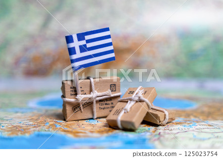 Flag of Greece near the parcels on the world map. World trade. Exports and imports of goods. Economy of the country Flag of Greece near the parcels on the world map. World trade. Exports and imports of goods. Economy of the country 125023754