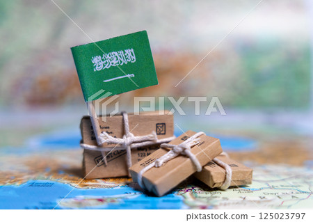 Flag of Saudi Arabia near the parcels on the world map. World trade. Exports and imports of goods. Economy of the country 125023797