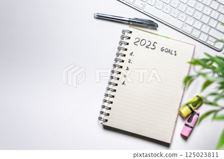 Notebook with goals for 2025 on white background. Top view. Working atmosphere. Year planning and goals Notebook with goals for 2025 on white background. Top view. Working atmosphere. Year planning and goals 125023811