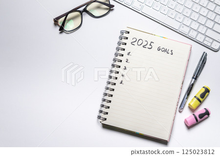 Notebook with goals for 2025 on white background. Top view. Working atmosphere. Year planning and goals Notebook with goals for 2025 on white background. Top view. Working atmosphere. Year planning and goals 125023812