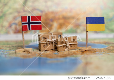 Humanitarian Aid Shipment Between Norway and Ukraine Depicted with National Flags and Parcel Boxes on World Map 125023920
