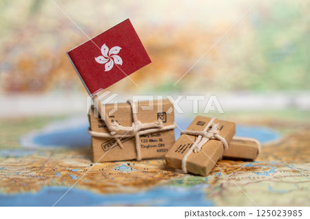 Packages wrapped in brown paper with a Hong Kong flag in the background, representing international delivery services across continents 125023985