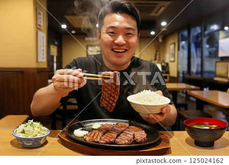 一名男子正在吃燒烤套餐 一名男子正在吃燒烤套餐 125024162