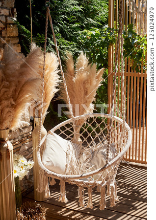 Wedding decoration. Floristics. Outdoor swing with pillows. A place for guests to relax Wedding decoration. Floristics. Outdoor swing with pillows. A place for guests to relax 125024979