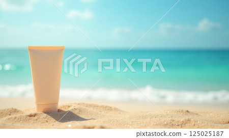 Sunscreen tube on sand against blurred ocean waves. Beach skincare mockup with copy space. Summer vacation and sun protection concept 125025187