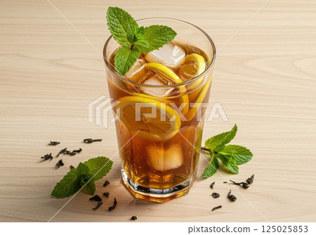 Refreshing iced tea with lemon and mint in a glass on wooden table 125025853