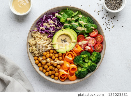 Tasty vegan buddha bowl with fresh vegetables and quinoa served on a light background Tasty vegan buddha bowl with fresh vegetables and quinoa served on a light background 125025881