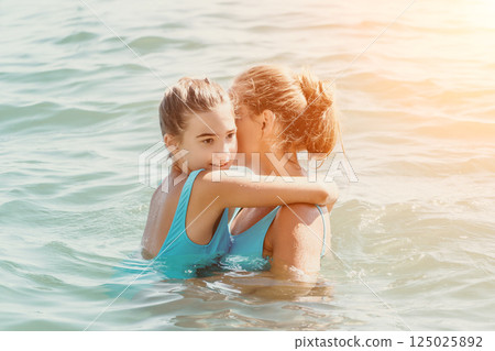 Mother and Daughter Embrace in the Ocean 125025892