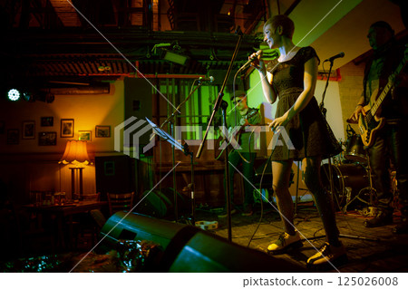 Band performs on stage, rock music concert in a nightclub. 125026008