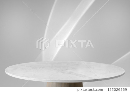 Round marble table top with abstract shadow drop on white wall background for mockup product display 125026369