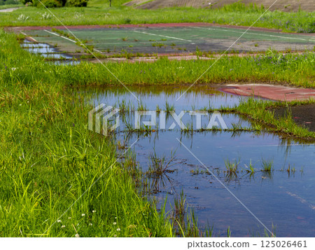 An old tennis court on a flooded riverbed 125026461