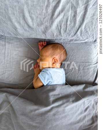Newborn Baby Sleeping Peacefully on Bed 125026497