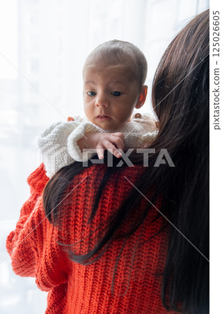 Tender Moment Between Mother and Baby by the Window 125026605