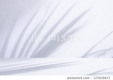 White table with palm tree shadow drop on white wall background for mockup product display 125026615