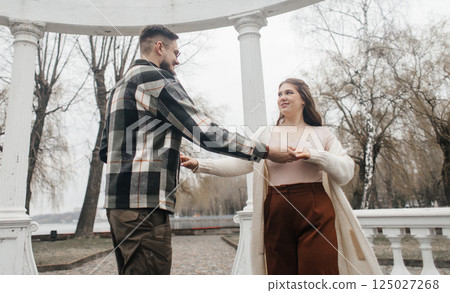 Romance outdoors dancing. Happy young couple dancing in stylish clothes. Romantic and spontaneous date moment Romance outdoors dancing. Happy young couple dancing in stylish clothes. Romantic and spontaneous date moment 125027268
