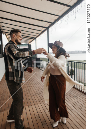 Romance outdoors dancing. Happy young couple dancing in stylish clothes. Romantic and spontaneous date moment Romance outdoors dancing. Happy young couple dancing in stylish clothes. Romantic and spontaneous date moment 125027270