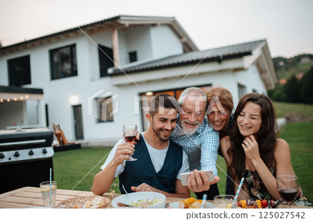 Family taking selfie during spring family barbecue. 125027542