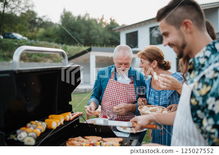 Family preparing food for a spring weekend barbecue. 125027552