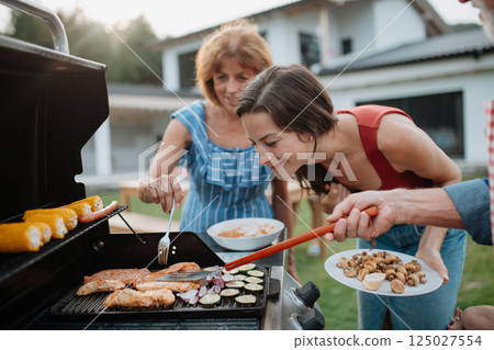 Family preparing food for a spring weekend barbecue. 125027554
