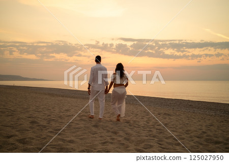 Couple Expecting Baby Walking by Sunset Ocean Waves 125027950
