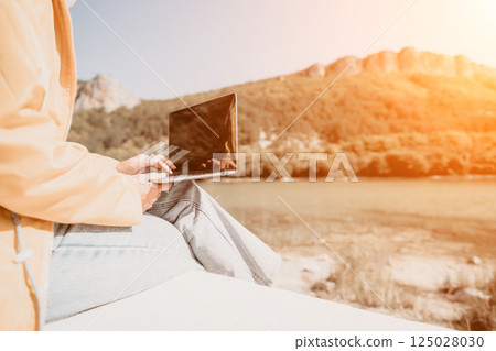 Laptop, Nature, Work - Woman Using Laptop Outside with Mountain Background in Sunny Day. Laptop, Nature, Work - Woman Using Laptop Outside with Mountain Background in Sunny Day. 125028030