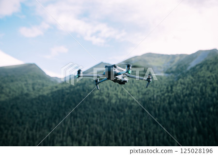 Drone flying in high altitude mountains 125028196