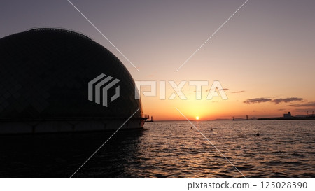Dome and sun setting over the sea 125028390