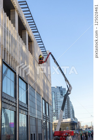 Construction crews and installers of high-rise buildings install fittings or lay electrical wiring 125028461