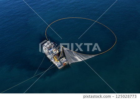 A bird's eye image of a large fishing vessel retrieving its nets. A bird's eye image of a large fishing vessel retrieving its nets. 125028773