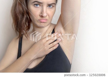 A woman unhappy, she is armpit hair grows. She doesn't like it, close up cropped photo A woman unhappy, she is armpit hair grows. She doesn't like it, close up cropped photo 125028806