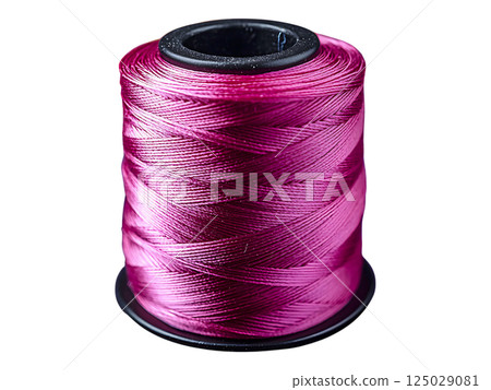 Closeup of a vibrant pink thread spool, surrounded by a blurred background of colorful thread spools.  A concept image representing creativity, craft, and textile artistry. 125029081