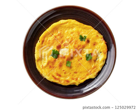 Delicious golden-yellow omelette garnished with fresh herbs, served on a dark brown plate. Perfect for breakfast, brunch, or menu imagery. Delicious golden-yellow omelette garnished with fresh herbs, served on a dark brown plate. Perfect for breakfast, brunch, or menu imagery. 125029972