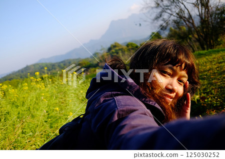 Asian young woman smiling and selfie with wildflower and beautiful landscape of valley Doi Luang Chiang Dao mountain, Chiang Mai Province of Thailand Asian young woman smiling and selfie with wildflower and beautiful landscape of valley Doi Luang Chiang Dao mountain, Chiang Mai Province of Thailand 125030252