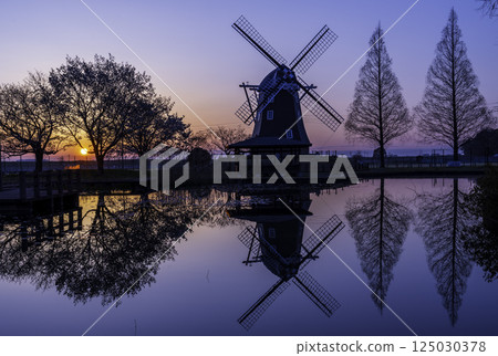 Windmills reflected on the water at Akebonoyama Agricultural Park in the morning glow 125030378