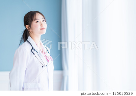 白色背景下一位年輕女醫生的肖像 白色背景下一位年輕女醫生的肖像 125030529