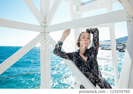 Beautiful woman in summer clothes walking on the beach by the sea Beautiful woman in summer clothes walking on the beach by the sea 125030760