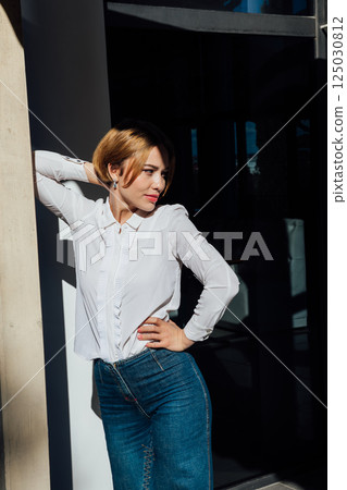 Portrait of a beautiful blonde woman fashionably walking on the street 125030812