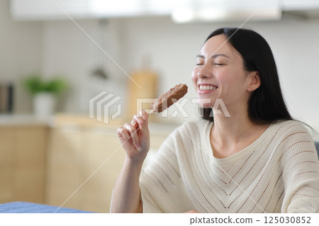 Happy asian woman eating chocolate ice cream Happy asian woman eating chocolate ice cream 125030852