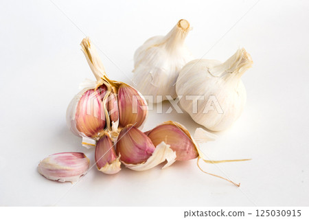 Garlic heads and cloves on white background Garlic heads and cloves on white background 125030915