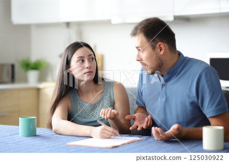 Confused interracial couple signing contract 125030922