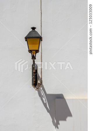 Lantern with its shadow on a white wall, Spain 125033009