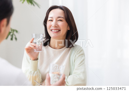 Couple holding glasses of water 125033471