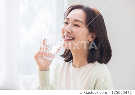 A woman holding a glass of water A woman holding a glass of water 125033472