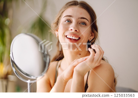 Woman worry about her face when she saw the problem of acne occur by a mini mirror. Pimples, acne 125033563