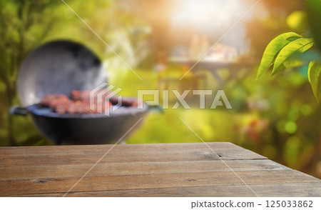 summer time in backyard garden with grill BBQ, wooden table, blurred background summer time in backyard garden with grill BBQ, wooden table, blurred background 125033862