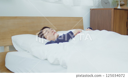 A woman sleeping in bed A woman sleeping in bed 125034072