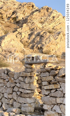 Serene mountain escape surrounds forgotten village walls where serene mountain escape meets preserved traditional stone construction near peaceful tourist attraction rooted in heritage. 125034149